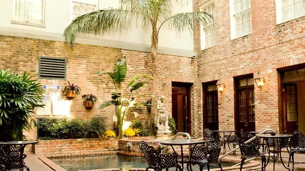A serene courtyard at The Quarter House featuring a small pool and lush greenery.
