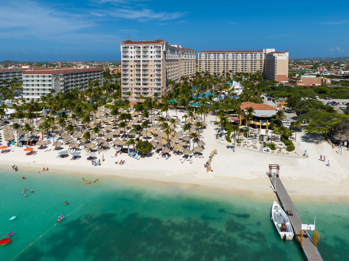 Exterior of Marriott's Aruba Surf Club resort timeshare showing beach and boat dock