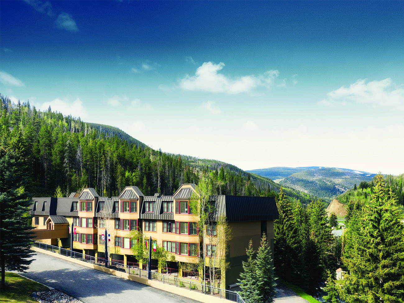 Exterior of Marriott's StreamSide Evergreen resort timeshare with forest-covered mountains in the distance