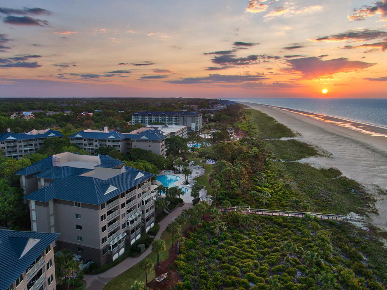 Exterior of Grande Ocean resort timeshare at sunrise showing dunes and beach